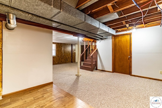 below grade area featuring stairway, wood finished floors, and baseboards