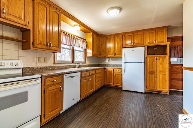 kitchen featuring dark wood-type flooring, decorative backsplash, brown cabinets, white appliances, and a sink