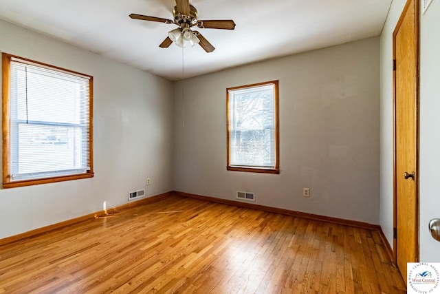 unfurnished room featuring baseboards, visible vents, light wood finished floors, and ceiling fan