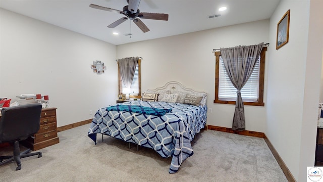 bedroom with baseboards, visible vents, and light colored carpet