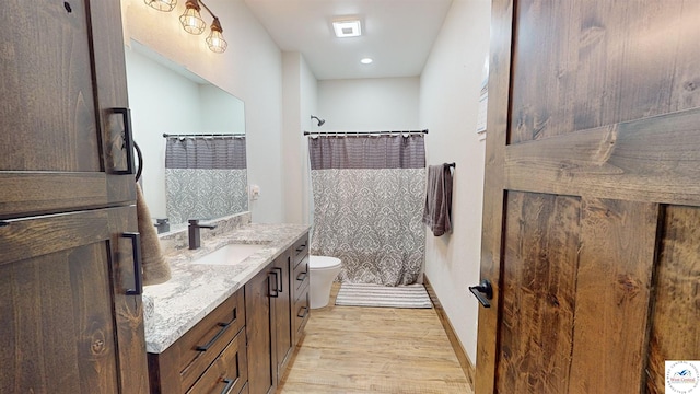 full bathroom with toilet, vanity, wood finished floors, a shower with curtain, and baseboards