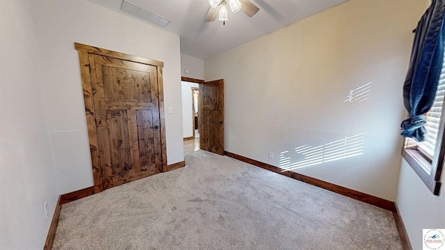 unfurnished bedroom featuring carpet floors, visible vents, ceiling fan, and baseboards