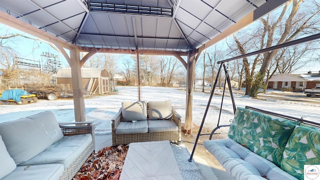 snow covered patio featuring a gazebo and an outdoor hangout area