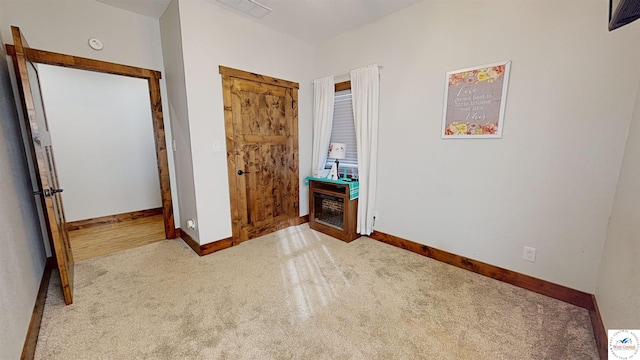 interior space with visible vents, baseboards, and light colored carpet