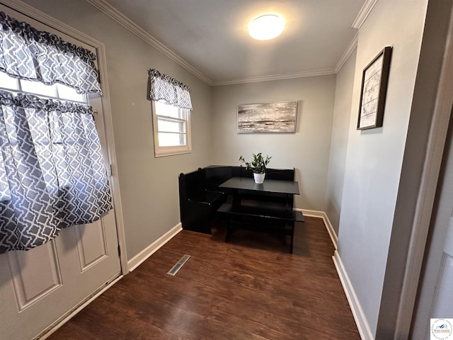 dining room featuring ornamental molding, dark wood finished floors, visible vents, and baseboards