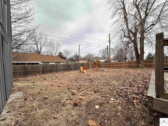 view of yard with a fenced backyard and a playground