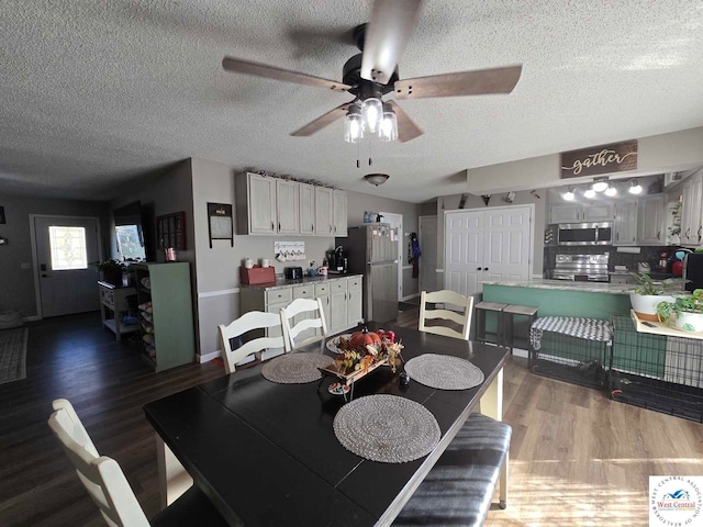 dining area with dark wood-style floors, a textured ceiling, and a ceiling fan