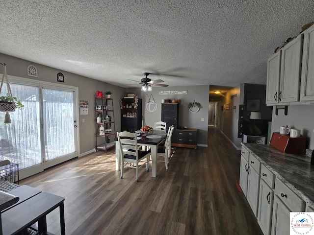 dining area with a textured ceiling, dark wood-style flooring, a ceiling fan, and baseboards