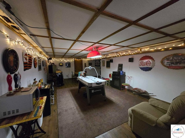 recreation room with coffered ceiling and dark wood-style flooring