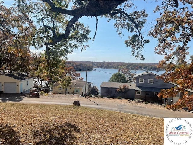 view of yard featuring a water view and a detached garage