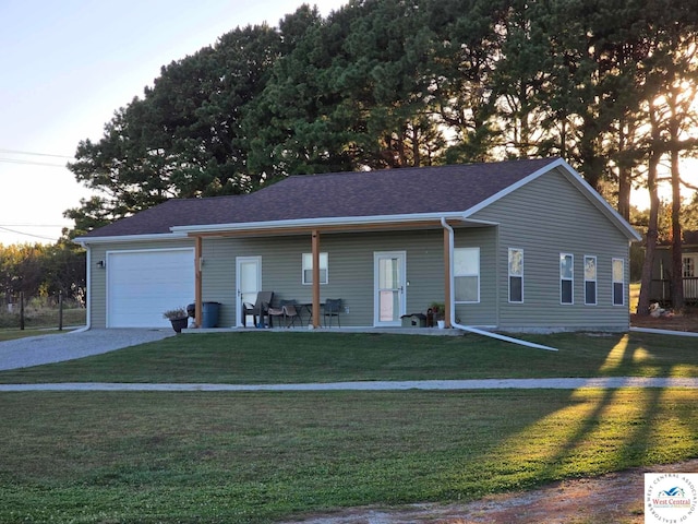 ranch-style home with an attached garage, driveway, a front yard, and roof with shingles