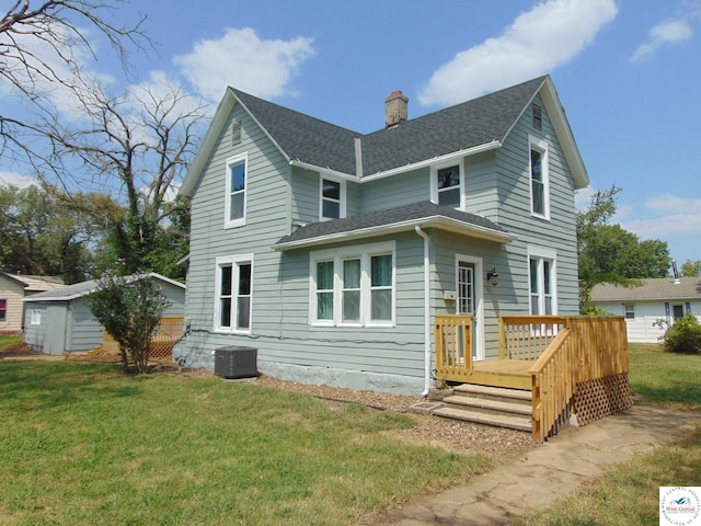 rear view of property featuring central AC, a shingled roof, a lawn, a storage unit, and a chimney