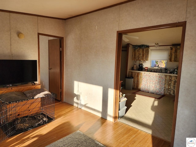 interior space with crown molding and light wood-style flooring