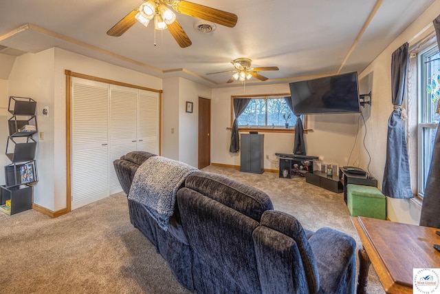 living area featuring carpet floors, baseboards, visible vents, and a ceiling fan