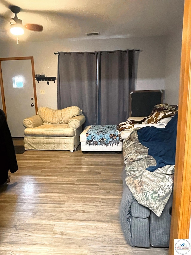 living area featuring ceiling fan, wood finished floors, and visible vents