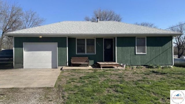 single story home featuring an attached garage, a front lawn, and concrete driveway