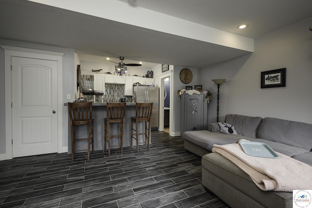 living area featuring recessed lighting, baseboards, and wood finish floors