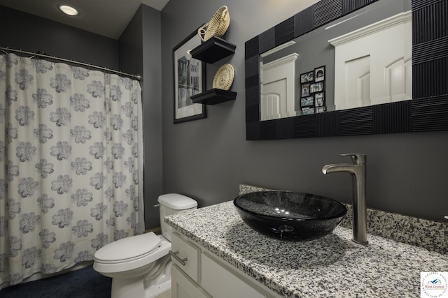 bathroom featuring curtained shower, toilet, and vanity