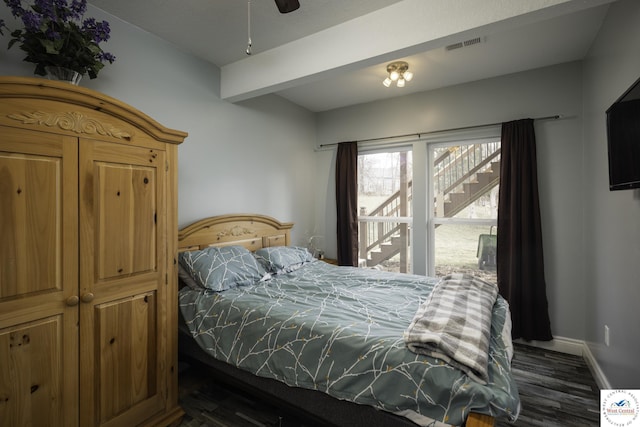 bedroom featuring visible vents, baseboards, beam ceiling, and dark wood finished floors