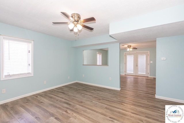 unfurnished room with wood finished floors, french doors, baseboards, and ceiling fan