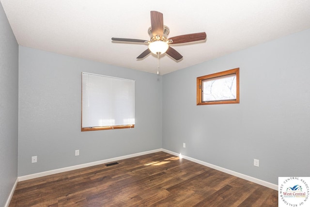 spare room featuring visible vents, a ceiling fan, baseboards, and wood finished floors