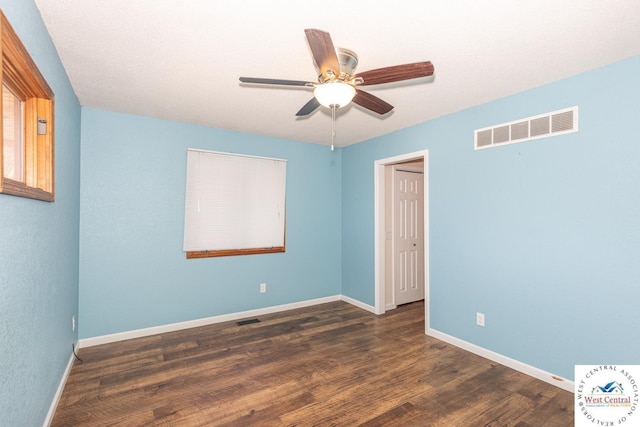 unfurnished room featuring ceiling fan, wood finished floors, visible vents, and baseboards