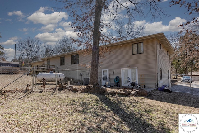 back of house featuring a gate and fence