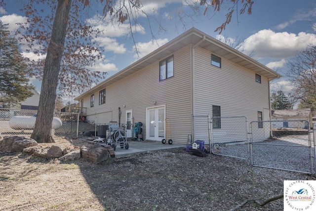 back of property with a gate, french doors, a patio, and fence