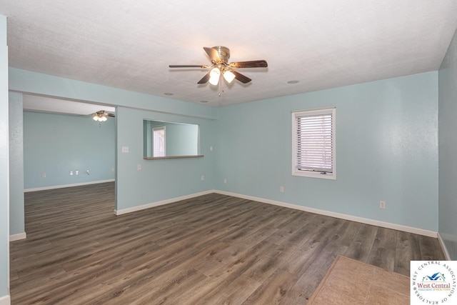 spare room featuring a textured ceiling, baseboards, ceiling fan, and wood finished floors