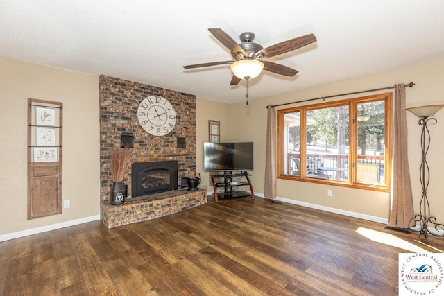 unfurnished living room with a ceiling fan, a brick fireplace, wood finished floors, and baseboards