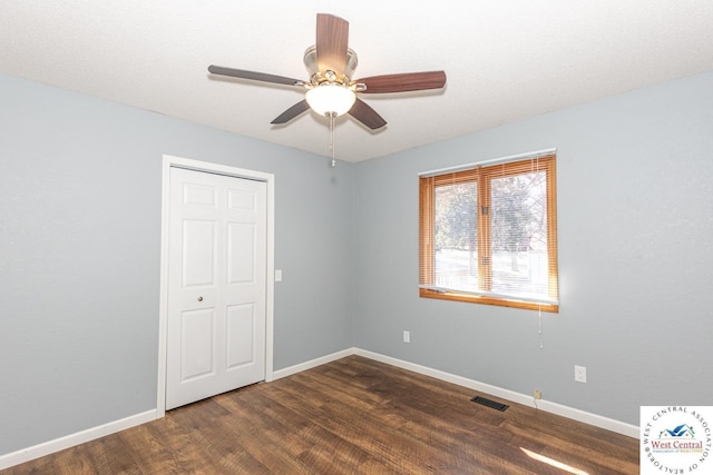 empty room featuring visible vents, a ceiling fan, baseboards, and wood finished floors