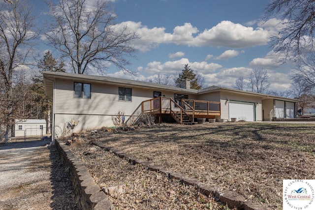 ranch-style house featuring a wooden deck, stairway, an attached garage, and a chimney