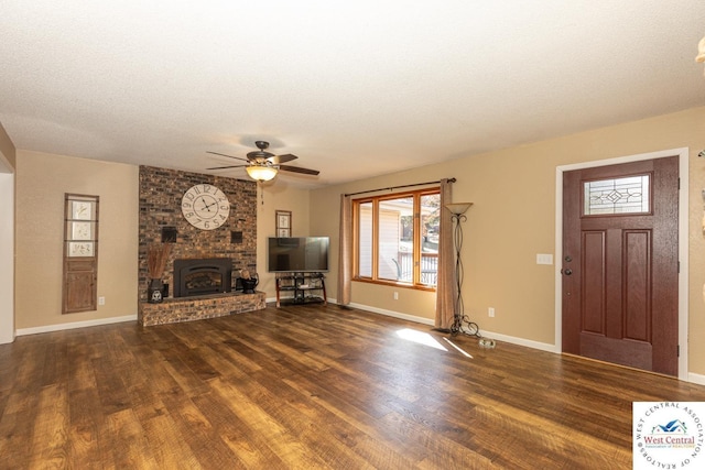 unfurnished living room with a fireplace, a textured ceiling, baseboards, and wood finished floors