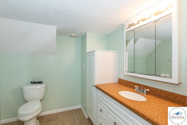 bathroom featuring vanity, baseboards, a textured ceiling, tile patterned floors, and toilet