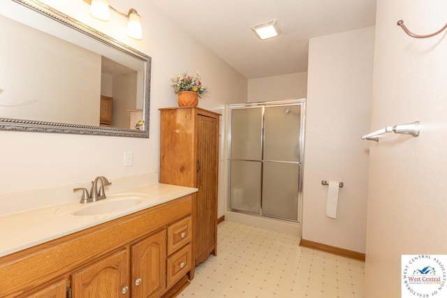 full bath featuring tile patterned floors, a stall shower, vanity, and baseboards