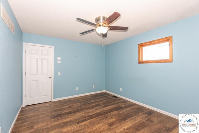 unfurnished room with ceiling fan, visible vents, baseboards, and wood finished floors