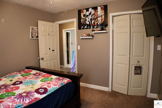 carpeted bedroom with a closet, baseboards, and a textured ceiling