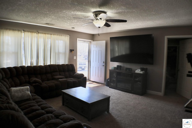 carpeted living area featuring baseboards, visible vents, a textured ceiling, and ceiling fan