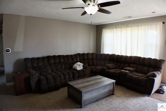 carpeted living room with a ceiling fan, visible vents, and a textured ceiling