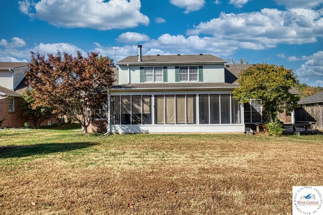 back of house with a sunroom, stucco siding, and a yard