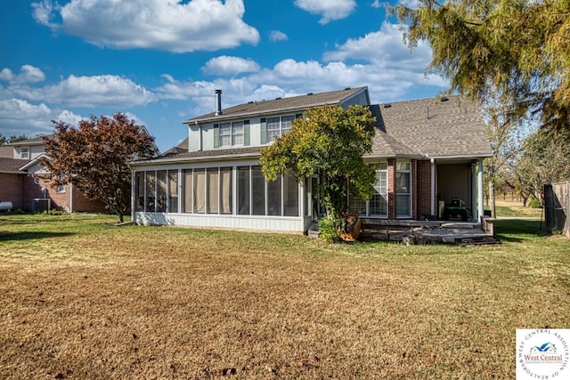 back of house featuring a yard, cooling unit, a sunroom, and brick siding