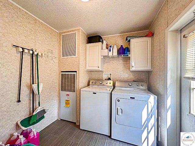 washroom with cabinet space, washing machine and dryer, dark carpet, and a textured ceiling