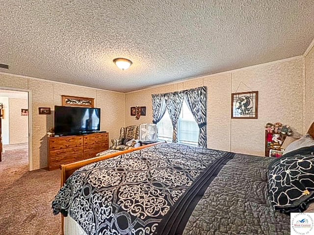 bedroom with a textured ceiling, carpet, and visible vents