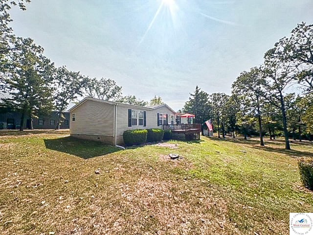 exterior space featuring crawl space, a lawn, and a deck