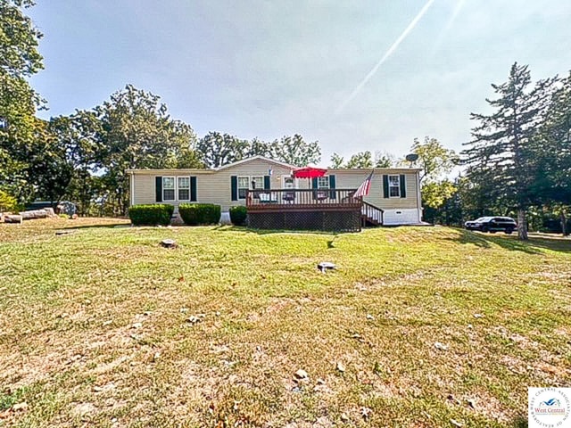 view of front facade with a front lawn and a wooden deck