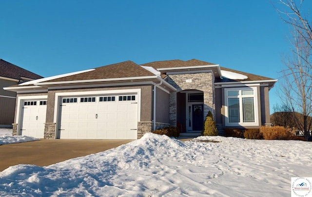 view of front of house with stucco siding, stone siding, driveway, and an attached garage