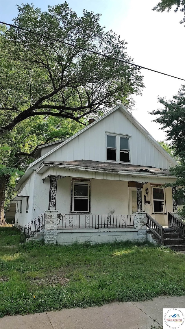 view of front of house with a porch and a front yard