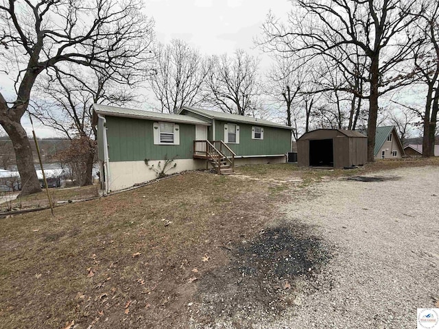 manufactured / mobile home with an outbuilding, driveway, and a storage unit