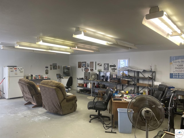 garage with a workshop area and freestanding refrigerator