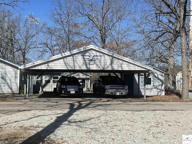 view of vehicle parking featuring a detached carport and driveway